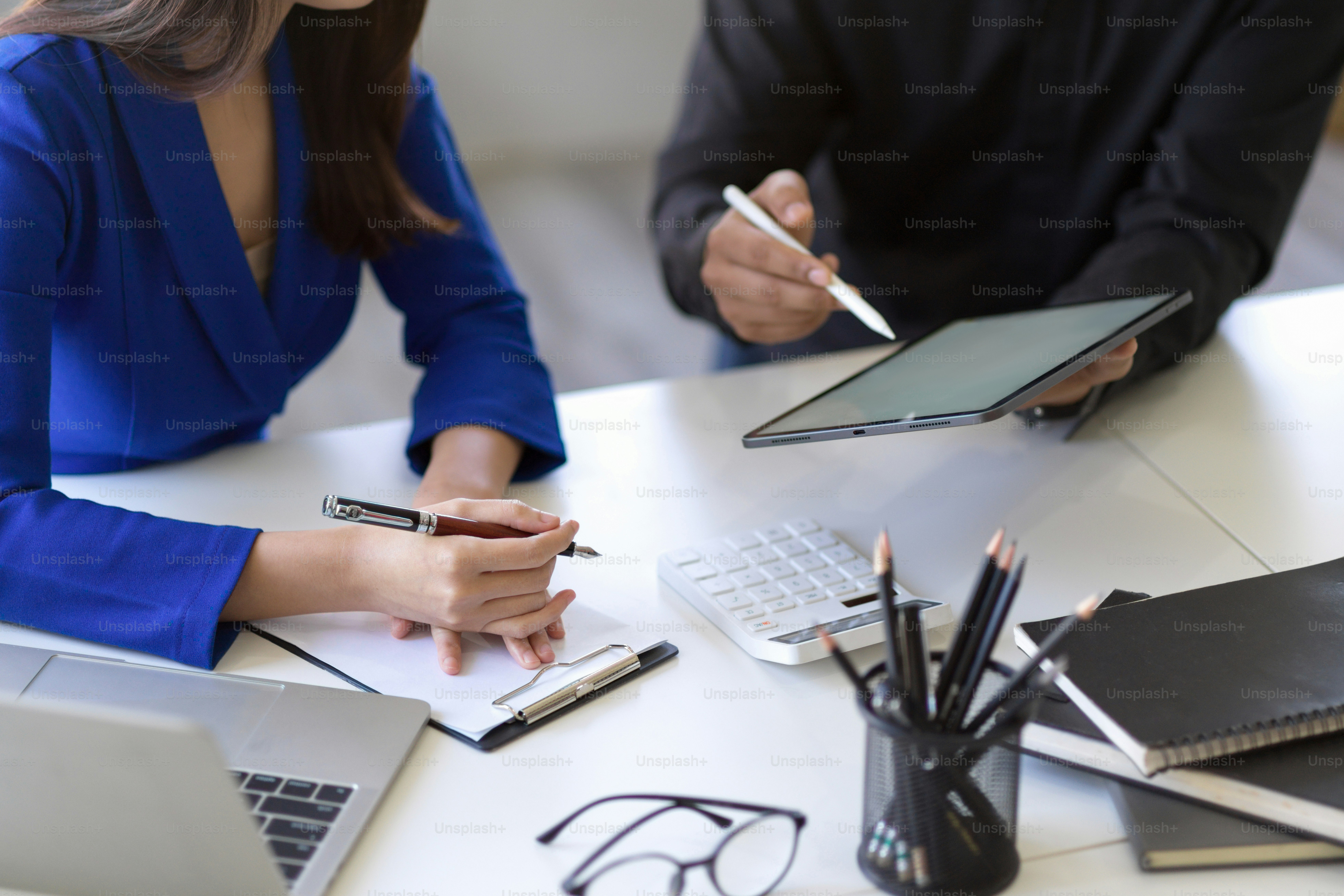 Cropped shot, Businesswoman and businessman planning their project strategy and using tablet computer in the office.